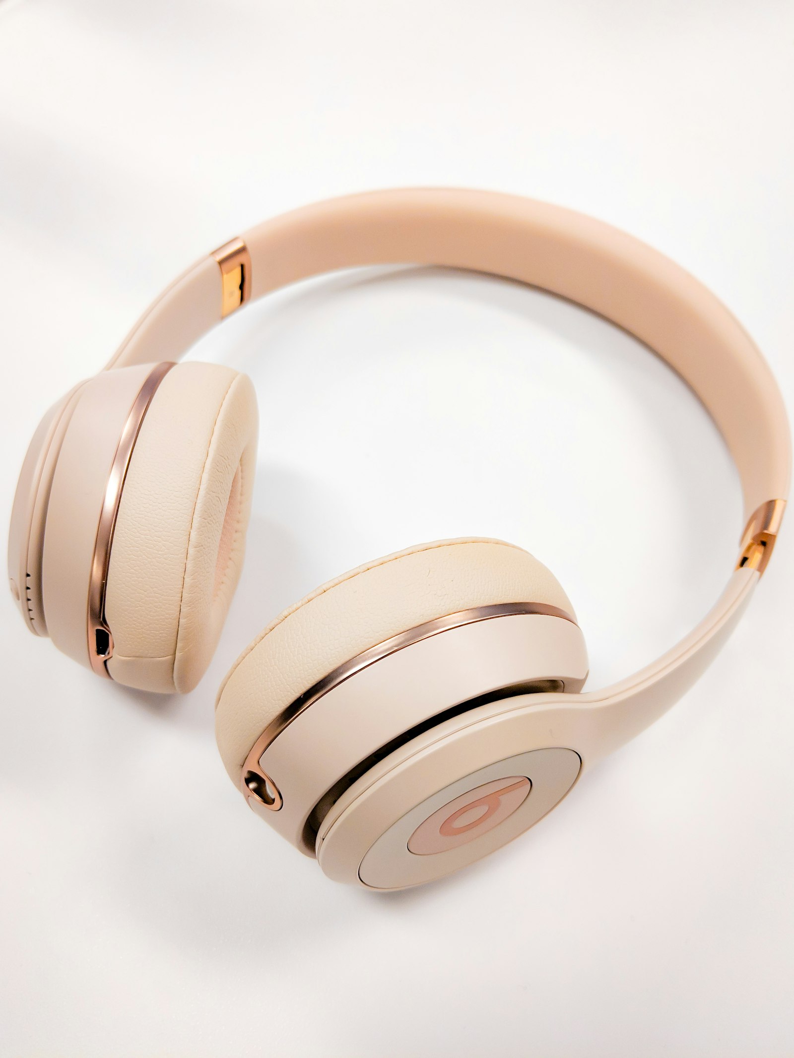 Close-up of cream ear pads with visible stitching and a slim headband.